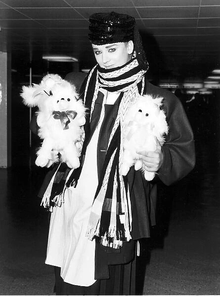 Singer Boy George arrives at Heathrow airport carrying two furry toy animals wearing
