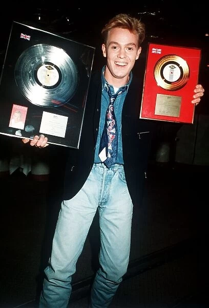 Singer Jason Donovan receives his Platinum and Gold Disc Awards at a party in London