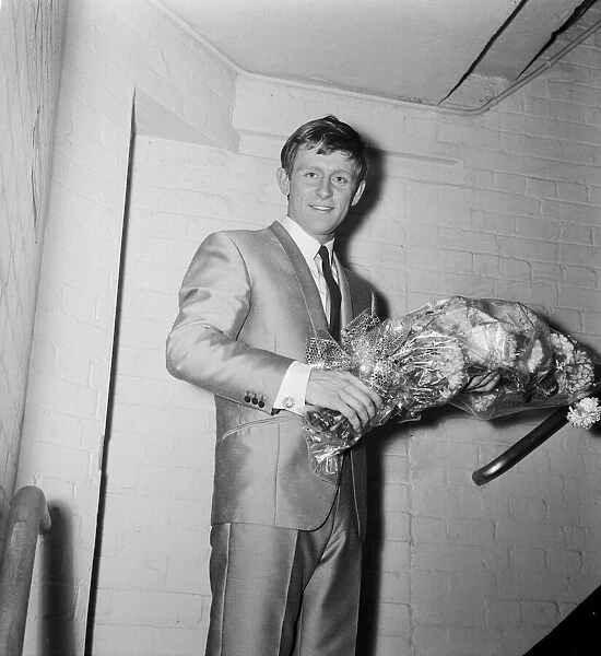 Singer Johnny Leyton holding a bunch of flowers backstage after giving a concert to