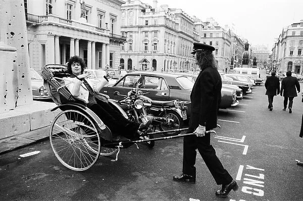 Singer Marc Bolan in a rickshaw in London. Drawing the rickshaw is Alphie O Leary