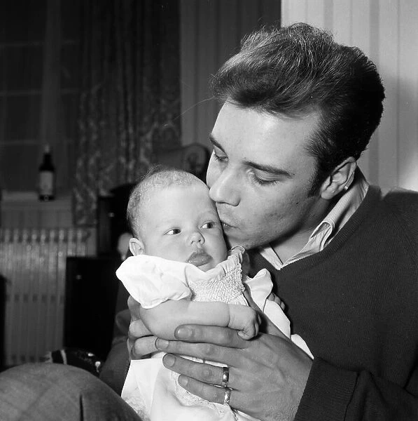 Singer Marty Wilde at home in Chiswick with his baby daughter Kim. 30th January 1961