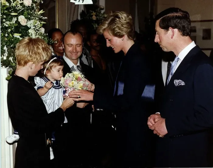 Framed Print : Singer and msusician Phil Collins with his family meeting Prince Charles