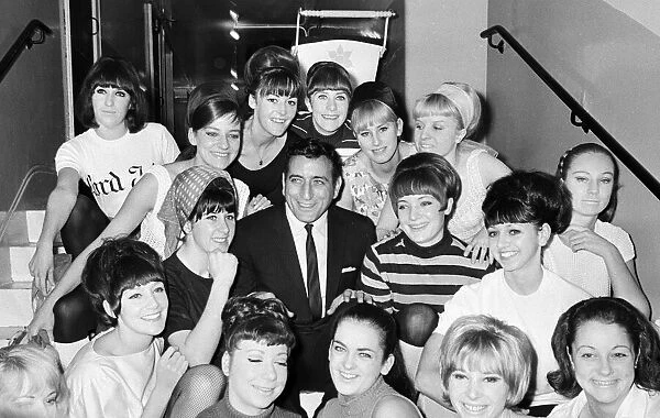 Singer Tony Bennett surrounded by chorus girls. 7th November 1965