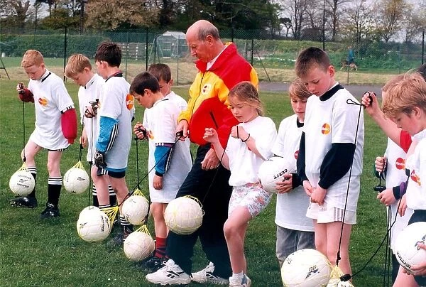 Sir Bobby Charlton gives tips to youngsters on Bullocksteads Sports Ground in May 1996 in