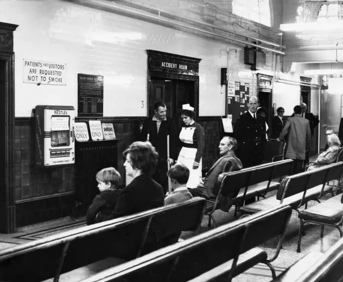 Framed Print : Sister Marjorie Cook talks to an out patient in the hall at at Ancoats Hospital in Mill