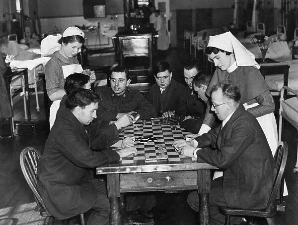 Sister Shine (right) and nurse Cockin playing cards with a group of boys in blue