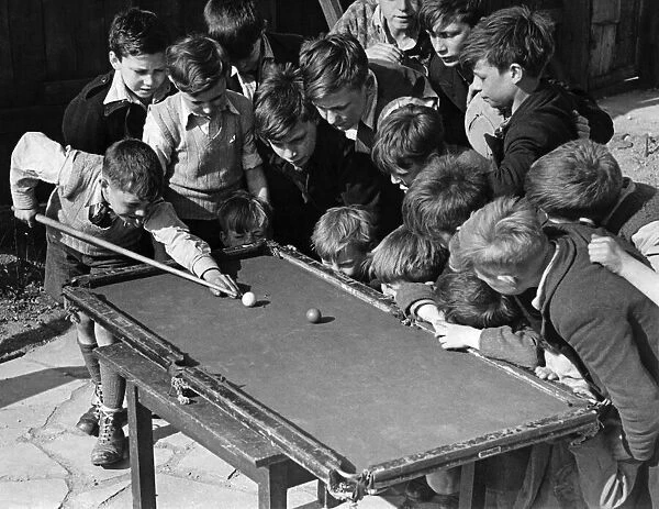 Sixteen tousled heads bend over a rickety billiard table at the Camel club, Bethnal Green