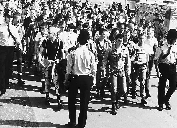 Skinheads being marched back to the railway station at Southend Essex where a strong