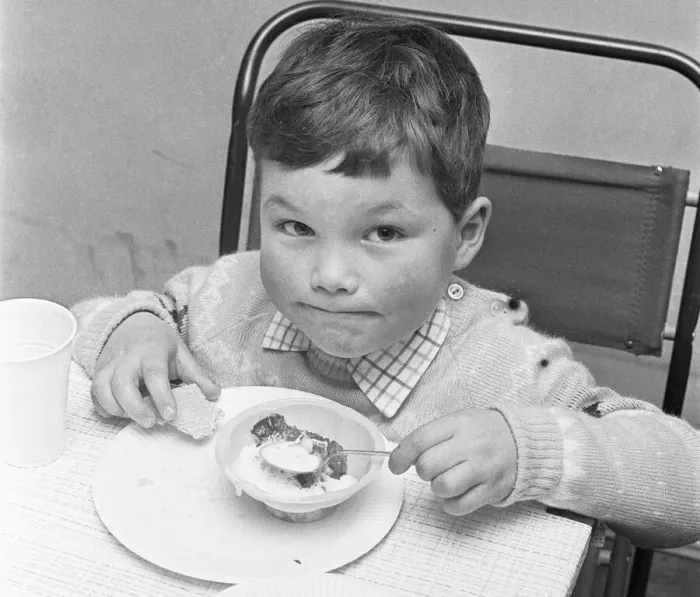 Framed Print : A small boy enjoying his jelly and ice cream during the Birch Copse School Christmas