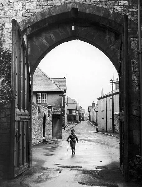 A small boy walks through the archway at the entrance of Ruthin Castle Denbighshire