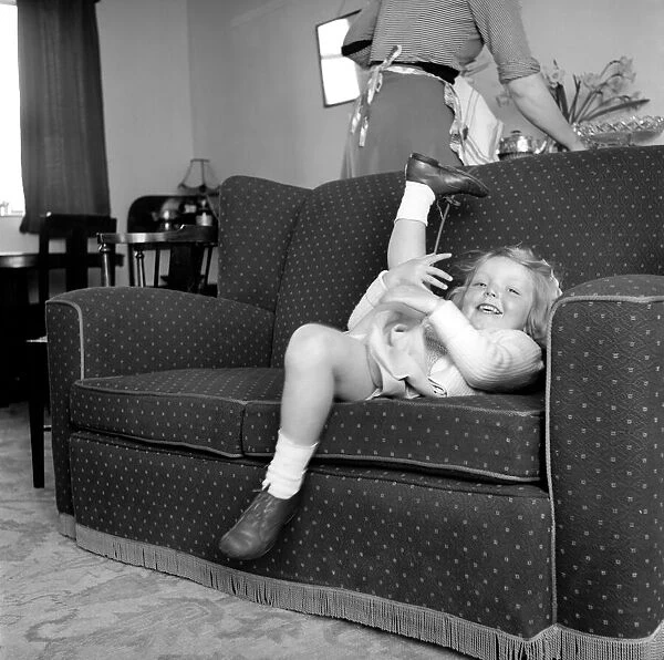 Small girl playing in the lounge in her home. 1954 A228b-001