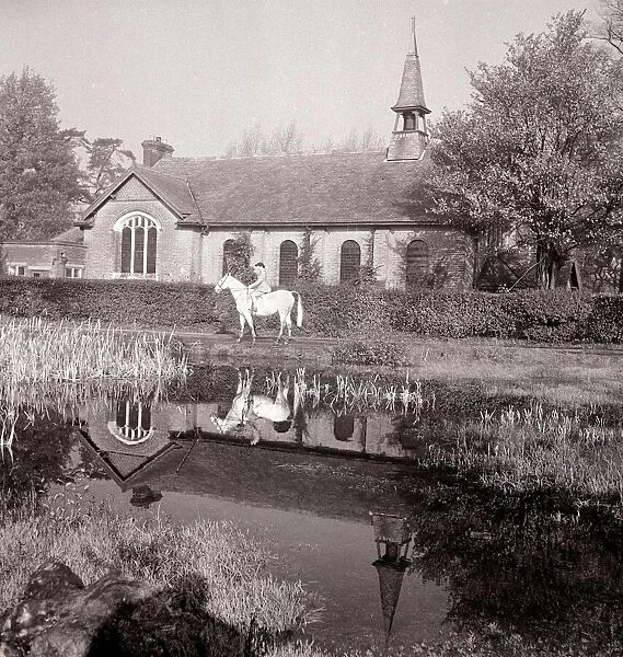 A small Methodist village church in Mill Hill Village London where a lady is out riding