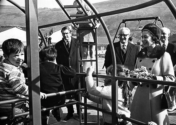 A smiling Queen Elizabeth II watches children in the play area at the opening of Aberfan
