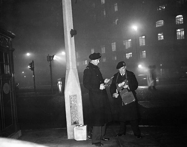 Smog wardens holding flares in thick fog in Central London. 5th January 1956