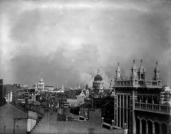 Smoke rises from behind the dome of St Pauls Cathedral after the first daylight bombing