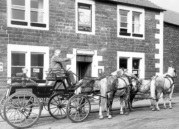 A snall coach an horse waiting outside The Grey Bull pub