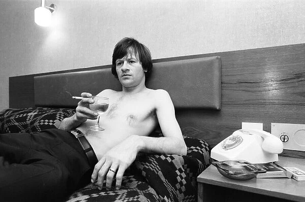 Snooker player Alex Hurricane Higgins relaxing with a drink