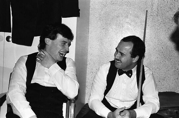 Snooker player Jimmy Whiteshares a joke with a fellow snooker player in the dressing room