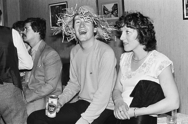 Snooker player Steve Davis letting his hair down wearing a straw hat and having a beer