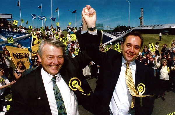 SNP leader Alex Salmond lifts Allan Macartneys arm after his stunning victory