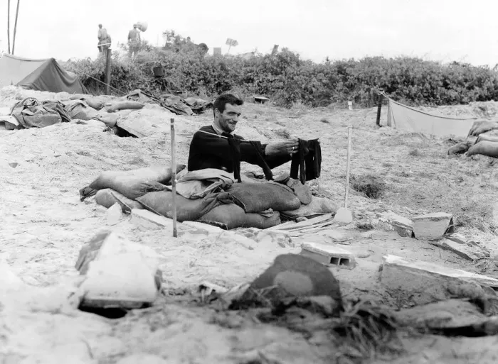Framed Print : A soldier hangs a pair of socks on a washing line outside his fox hole on a French beach Framed Print : A soldier hangs a pair of socks on a washing line outside his fox hole on a French beach