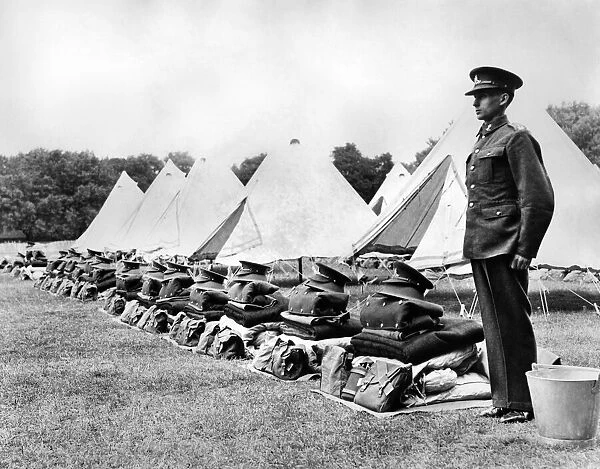 A soldier stands to attention beside neatly folded kit during an inspection of 52nd