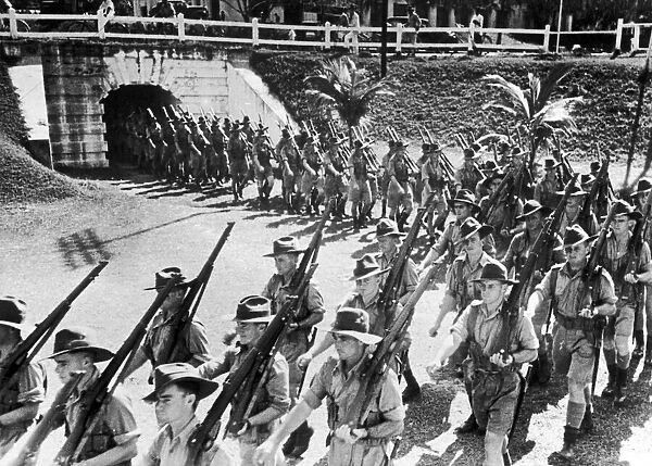 Soldiers of the Australian Imperial Force march into the parade ground in Malaya during