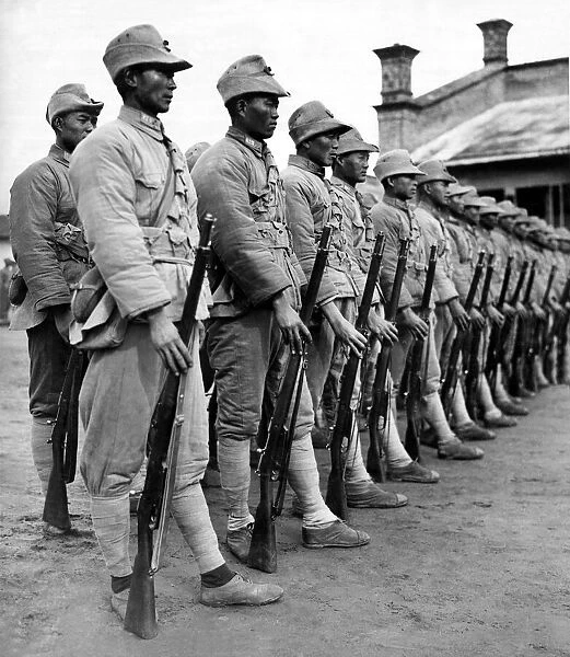 Soldiers of the Chinese defence force standing in line wearing uniform