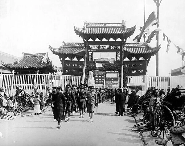 Soldiers of the Chinese government march under the entrance to the Viceroy