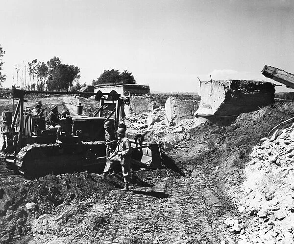 Soldiers digging with a digger during second World War. Circa 1940s
