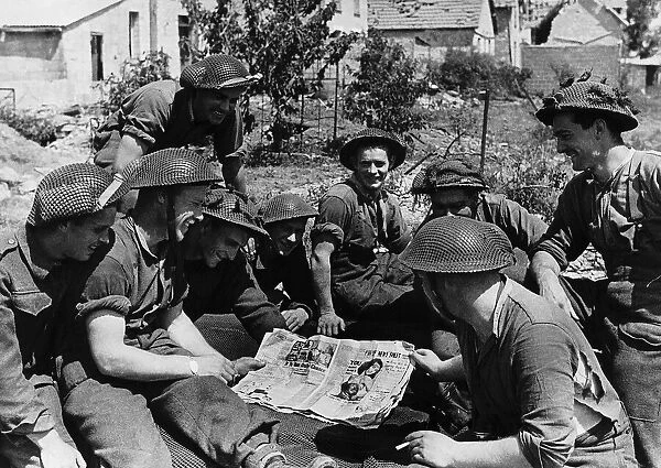 Soldiers during the invasion in France look at pin up pictures 1944