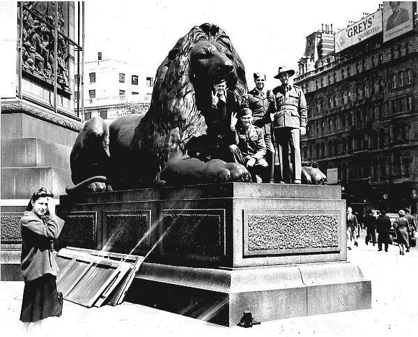 Soldiers on one of the lions in Trafalgar Square during WW2 VE-Day victory celebrations