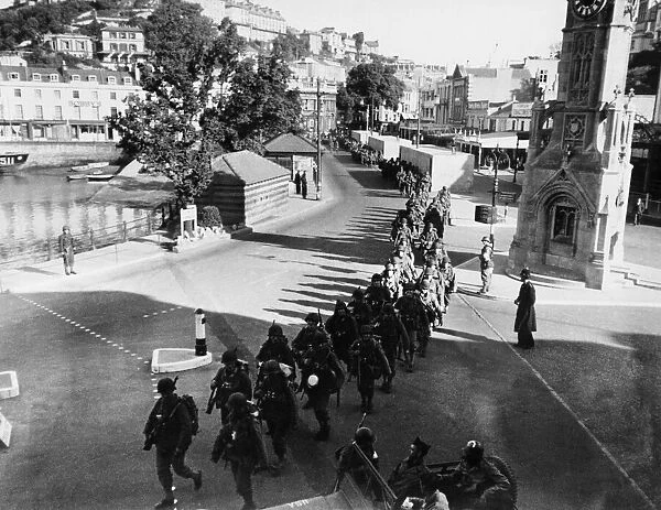 US soldiers march along the strand in Torquay. June 1944 prior to embarking on ships that