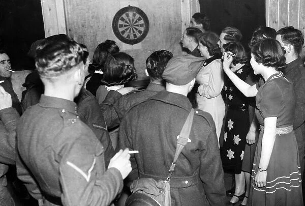 Soldiers play darts at the Wayfarers Club with local girls in Liss, Hampshire