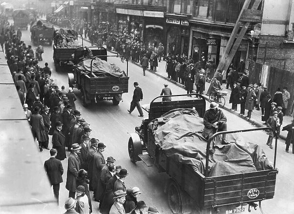 Soldiers ride shotgun as a food convoy passes through central London