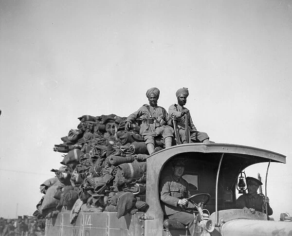 Soldiers riding on the top of a fully laden lorry. One of the supply train of the 3rd