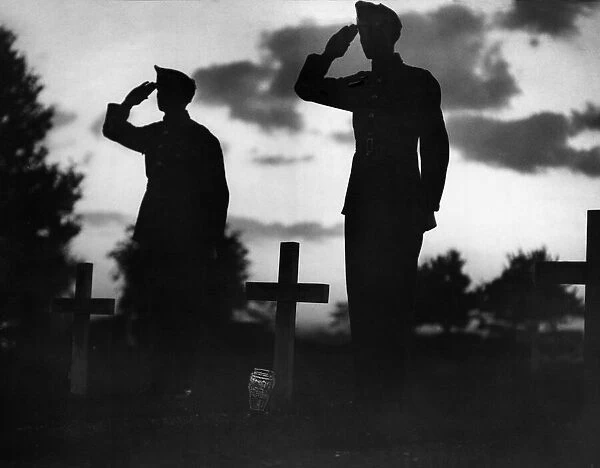 Soldiers salute at a cemetery as they remember comrades that died during the Battle