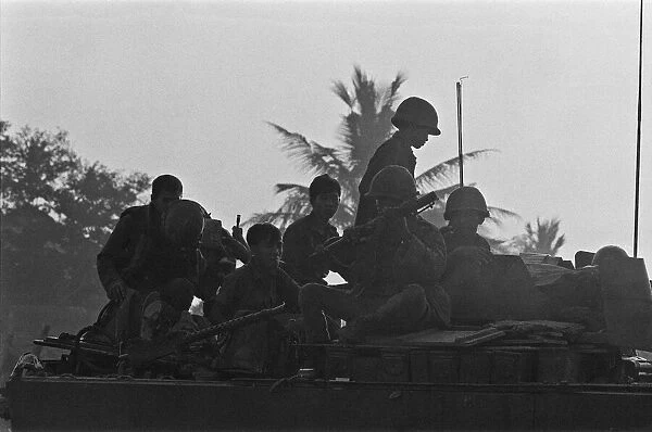 Soldiers of the South Vietnamese army watch from the top of an armoured personnel carrier