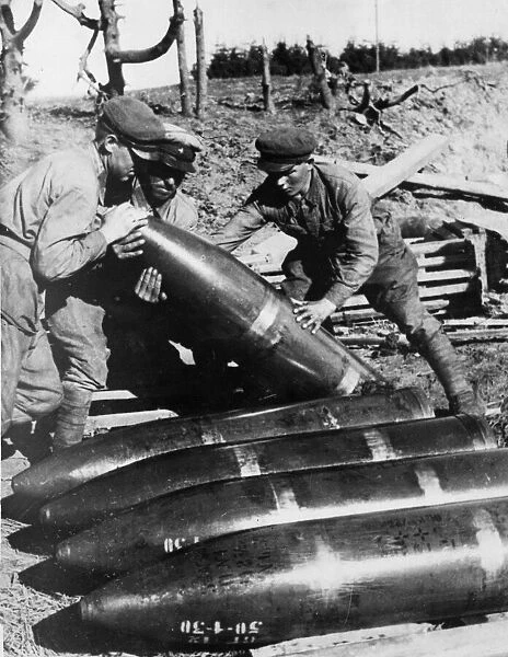Soldiers of the Soviet Red Army, prepare shells for a large calibre Howitzer somewhere