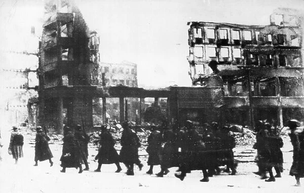 Soldiers of the Soviet Red Army walking through the streets of battered Stalingrad during
