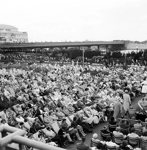 Southport, Merseyside, crowds of people relax in the Floral Hall Gardens as they listen