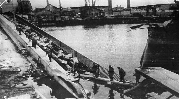 Soviet Red Army troops cross a bridge over the River Spree as they now gradually close