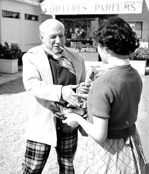 Spanish artist Pablo Picasso shaking hands with a young woman at the Cannes Film