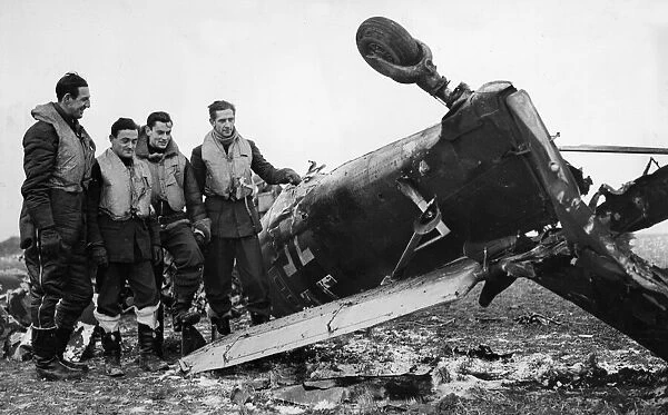 Spitfire pilots of RAF Fighter Command pose beside the wreckage of a Junkers Ju 87 Stuka