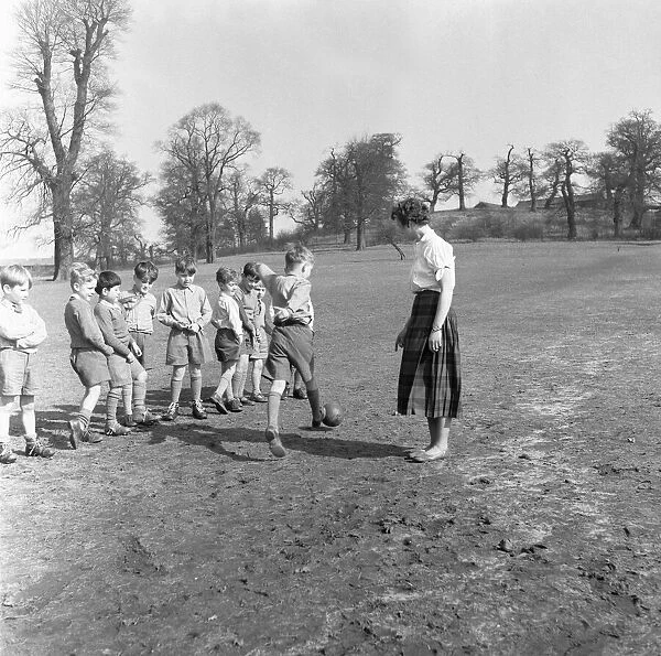 Sports mistress, Miss Reid, teaches football to the boys of Park Hill School, Kingston
