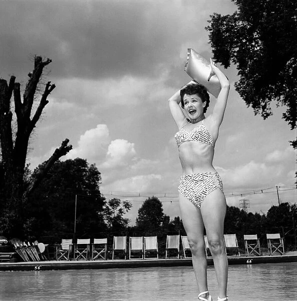 Stage and film actress Betty Paul wearing a bikini by the pool. July 1950 O25773