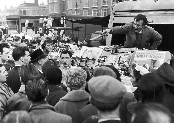 A stall holder at Petticoat Lane market serves another customer as crowds descended