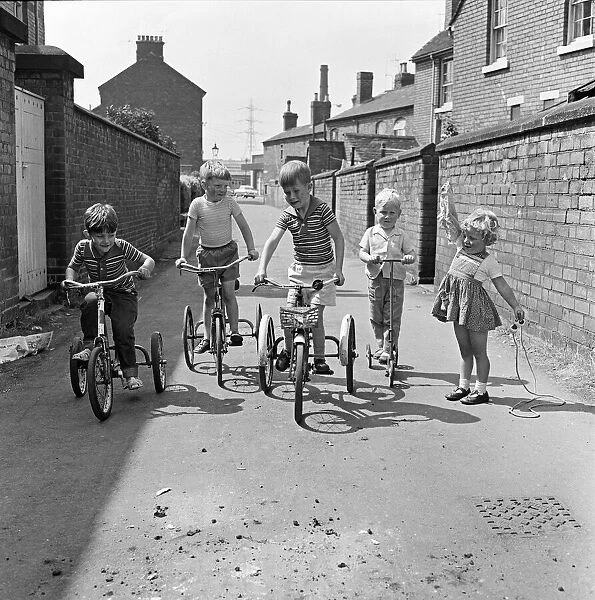 Under starters orders. Boys on their tricycles prepare to race in the back lanes of