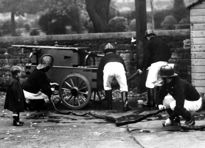 Framed Print : A startled little boy watches firemen in action in Morpeth on October 14, 1950