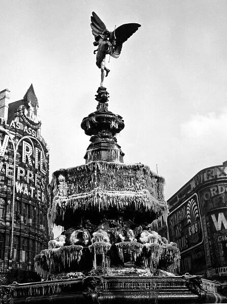 The statue of Eros in Piccadilly Circus, London covered in frozen icicles